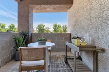 A patio with a table and chairs and a large window